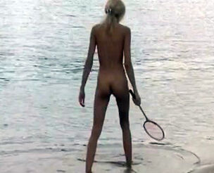 Slim bare teenages frolicking badminton on a sea beach.